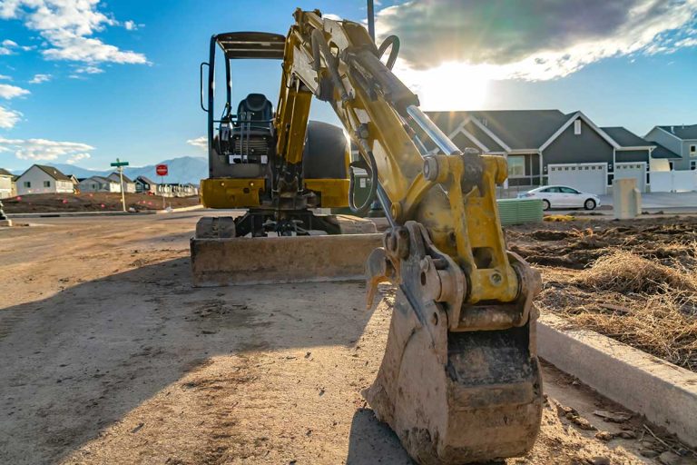 An excavator land clearing and levelling the ground